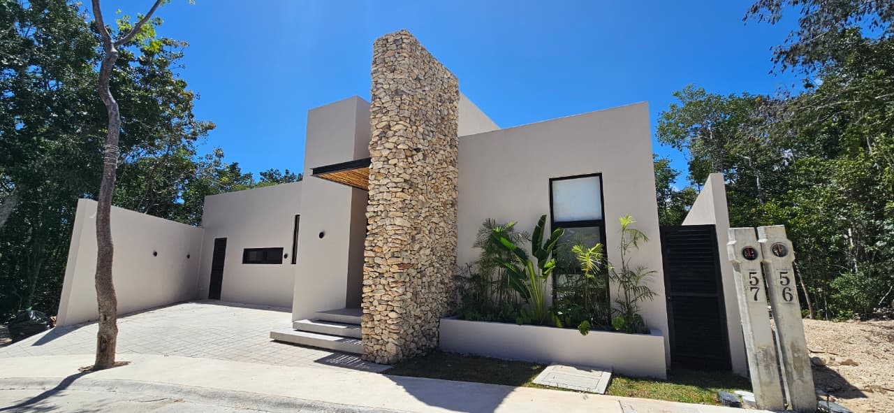 Casa Juuba — fachada principal con torre de piedra